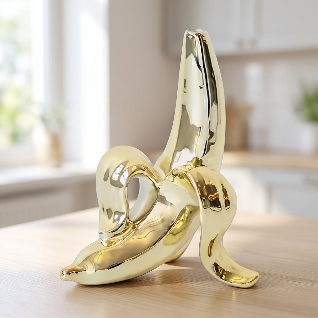 Gold ceramic peeled-banana-shaped decorative vase displayed on a bright kitchen countertop