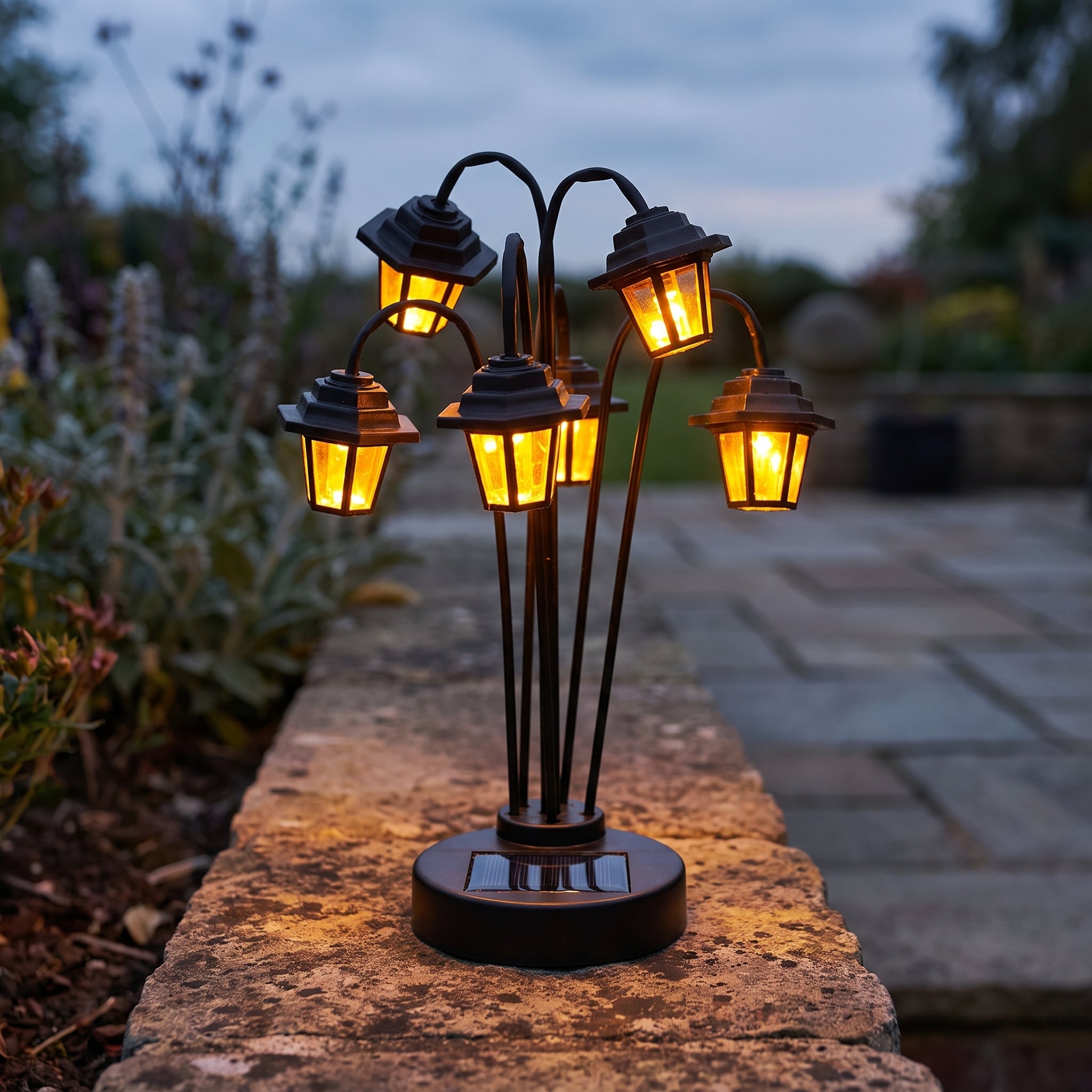 Solar-powered retro street lamp shaped garden lantern with six glowing LED lamp heads on a stone garden path at dusk